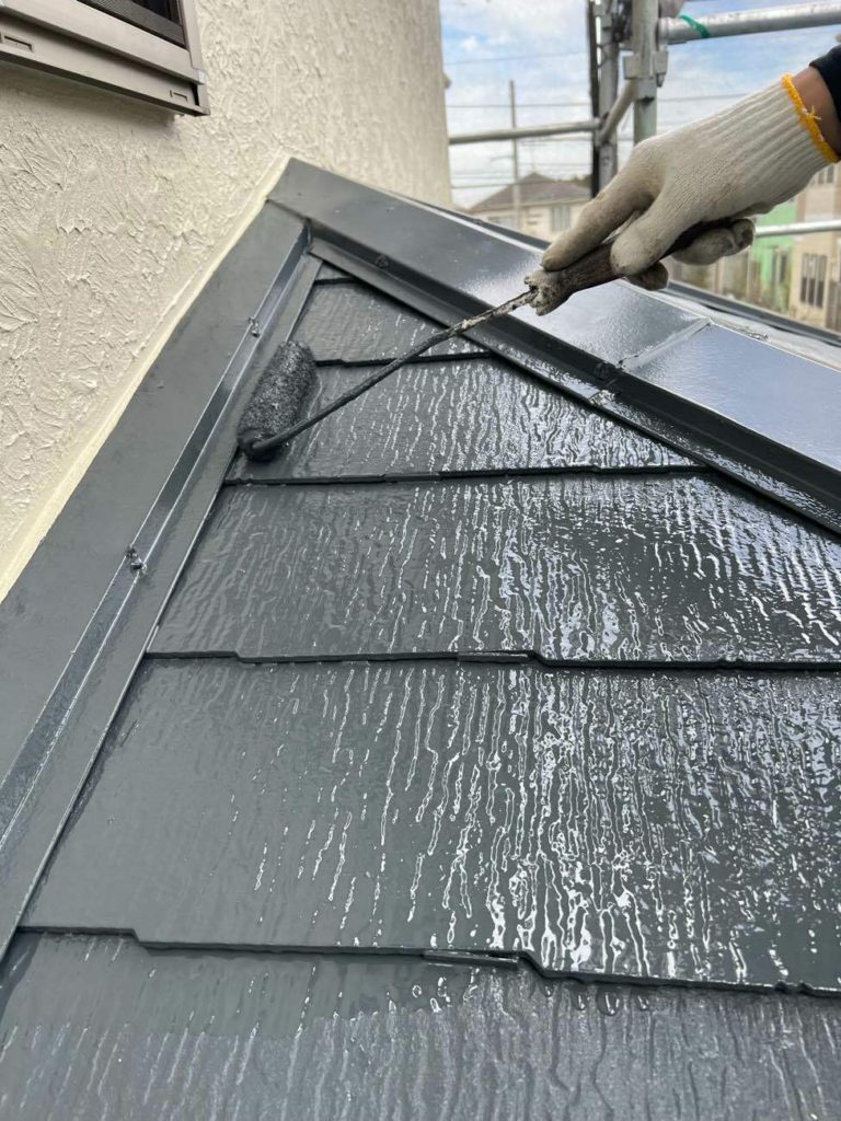 スレート屋根の上塗りを行う様子です。下屋根部分も塗装を行っていきます。