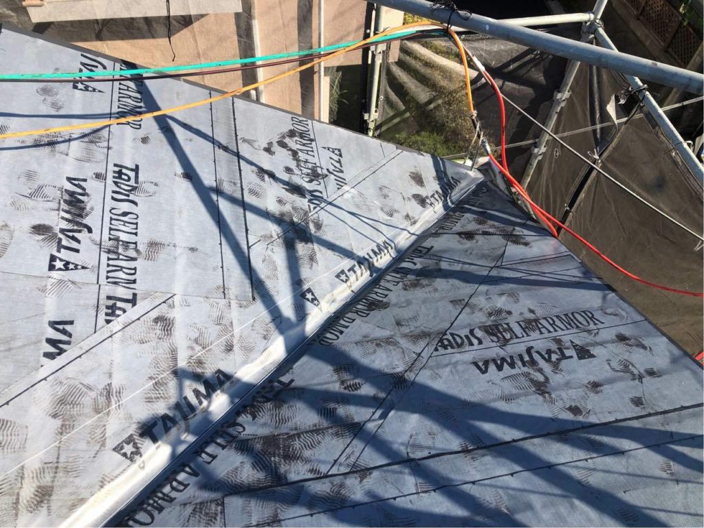 屋根カバー工事にて、防水紙を設置している様子です。