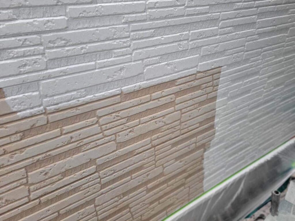 外壁の1回目の下塗りを行う様子です。ユウマペイントでは下塗りを2回行います。理由は、1回目の下塗りのシーラーは「吸い込み止め」という効果があり、サイディングでもモルタルでも、外壁材が劣化すると「毛細管現象」で塗料を吸い込んでしまう現象が発生し、その吸い込みを止めてくれるのが1回目の下塗りだからです。いきなりフィラーを塗って1回の下塗りで仕上げてしまうと、中の成分だけ吸い込まれたり、顔料だけが表面に残る状態になり弱い塗膜になってしまうので、下塗りを2回実施しています。