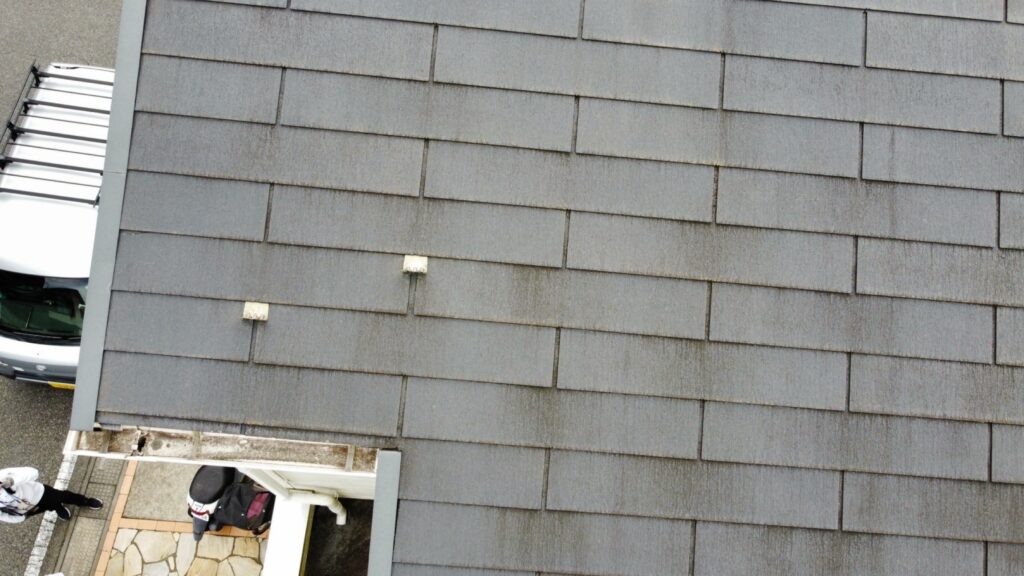 施工前のスレート屋根の写真です。経年劣化によりサイディング同様に屋根表面のコケの発生が見受けられます。