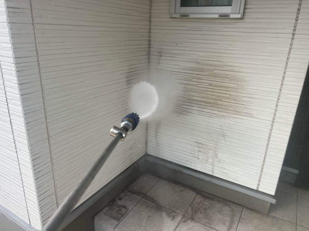 高圧洗浄を行う様子です。高圧洗浄は、塗装を長持ちさせるために非常に重要な工程です。高圧洗浄機で屋根が外壁の汚れや古い塗膜を落とすことで、新しい塗料がしっかりと密着し、剥がれやひび割れを防ぐための大切な工程になります。