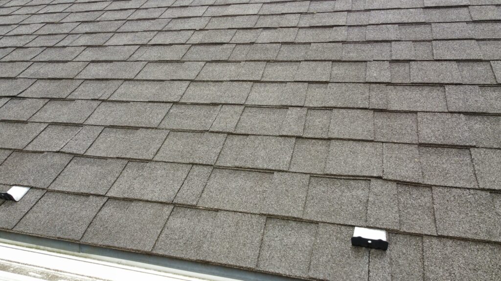 屋根はアスファルトシングルです。今回は、棟板金や雨押えの塗装、釘頭部分の補修をさせていただきます。