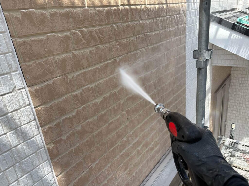 足場を設置した翌日は高圧洗浄を行います。高圧洗浄は、外壁や屋根の塗装を長持ちさせるために非常に重要な工程です。高圧洗浄機を使用して、外壁や屋根の汚れや古い塗膜をしっかりと落とすことで、新しい塗料が密着し、剥がれやひび割れを防ぐことができます。