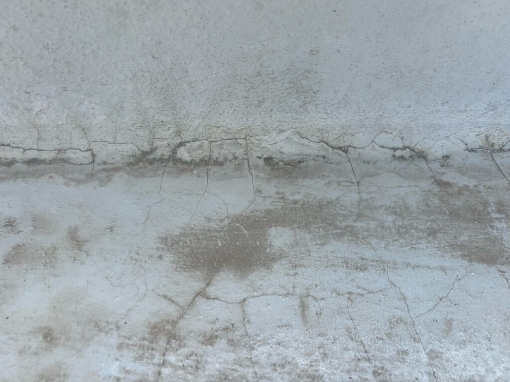 施工前のベランダ土間部分です。経年劣化や厚塗りによって硬化し、ひび割れ（通称：バキバキ）が目立つようになります。この状態を放置すると、見た目の劣化だけでなく、お客様が防水層自体の問題と誤解し、不安を感じる原因になります。