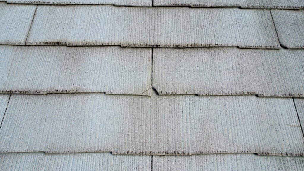 割れはあまり大きくない程度のものがほとんどでした。スレート屋根自体は防水性が低く、表面の塗装（塗膜）で防水しています。紫外線や雨風により塗膜が劣化すると、スレート本体が雨水を吸収しやすくなります。<br />
吸水と乾燥による膨張・収縮を繰り返すことで、屋根材にダメージが蓄積し、最終的にひび割れや欠けが発生することが主な原因として挙げられます。