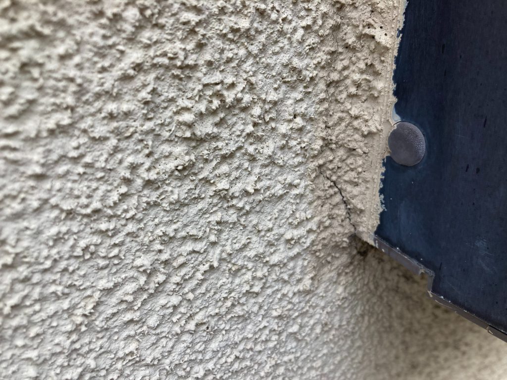 サッシまわりにひび割れ（クラック）が見られました。モルタル外壁によく現れるひび割れ（クラック）。経年劣化はもちろんですが、地震や交通振動、地盤の弱さなどで建物がわずかに動くと、 壁の一部に力が集中してひび割れが発生します。