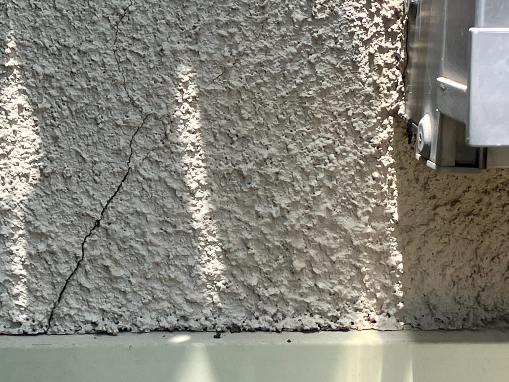 ひび割れが多数見られました。モルタル外壁によく現れるひび割れ（クラック）。経年劣化はもちろんですが、地震や交通振動、地盤の弱さなどで建物がわずかに動くと、 壁の一部に力が集中してひび割れが発生します。