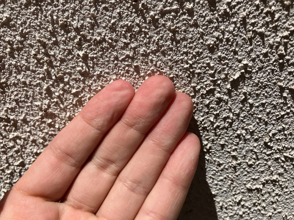 手でこすると白い粉が付着するチョーキング現象が見られました。チョーキング（白亜化）は、経年劣化により塗膜が粉状になり表面に現れる現象で、塗装の防水機能が低下した「塗り替えのサイン」です。手のひらで触ると白い粉が付着し、新築や前回塗装から約7〜15年後に発生しやすい。放置すると防水性が無くなり雨漏りや外壁のひび割れに繋がるため、塗装による補修を推奨いたします。