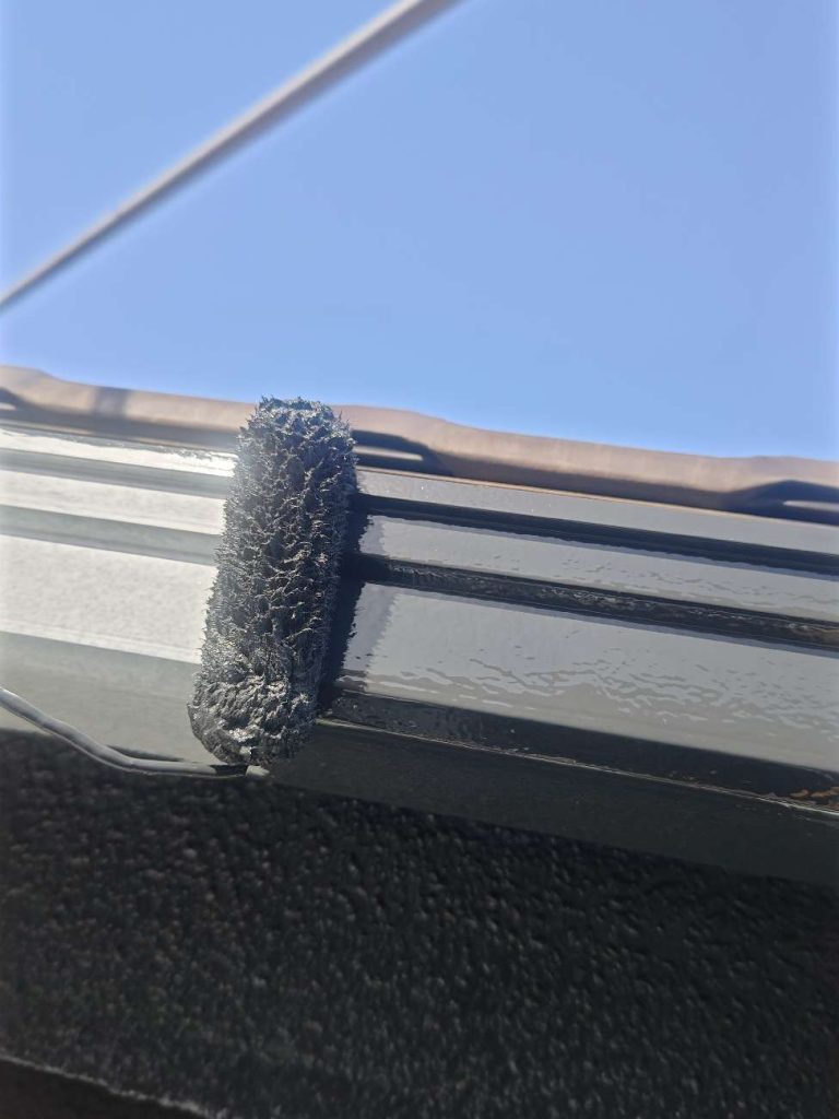 横樋の塗装をする様子です。塗装前にケレン・シンナー拭き（脱脂）・下塗りを行った後で下屋根・外壁と同じく日本塗装名人社の無機UVコートシリーズ（溶剤）を塗装します。