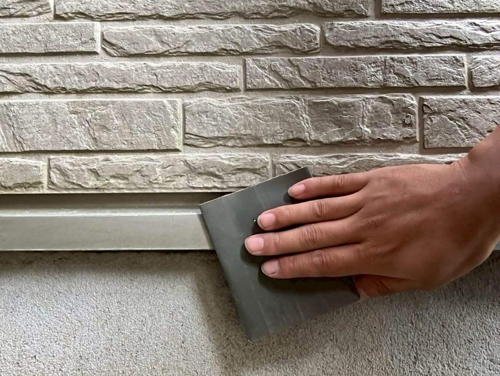 水切りのケレン処理を行う様子です。ケレン処理とは、旧塗膜やサビ、汚れを落とし、表面を整える下地処理のことを言います。ケレン処理をした後にシンナー拭きをすることで塗料の密着力を高めています。この作業を念入りに行えば行うほど、下塗り材の密着力が高まるためユウマペイントでは重要視している工程の一つです。