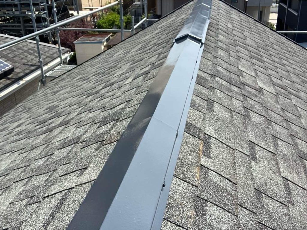 棟板金補修工事後のアスファルトシングル屋根写真です。アスファルトシングルは通常スレート屋根よりも耐用年数が長いのですが板金部分はどうしても錆や色褪せ、浮きなどの劣化が出てしまうため、塗装をさせていただきました。