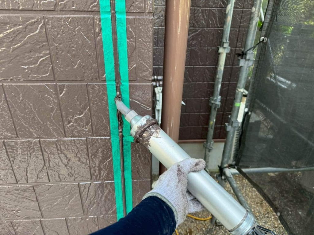 ユウマペイントでは塗装工事が終わってからシーリング撤去打ち替えを行う「後打ち」を基本としています。使用する塗料によって先打ちになる場合もありますが、無機塗料の場合は後打ちで施工いたします。写真は、既存のシーリングを撤去し、プライマーを塗布後に新しいシーリング材を充填している様子です。