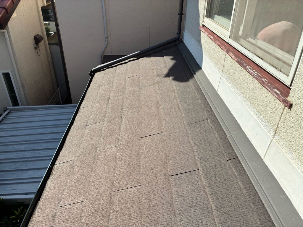 スレート下屋根の施工前写真です。屋根の現地調査時に見るポイントは色褪せや塗膜の浮きや剥がれなどです。