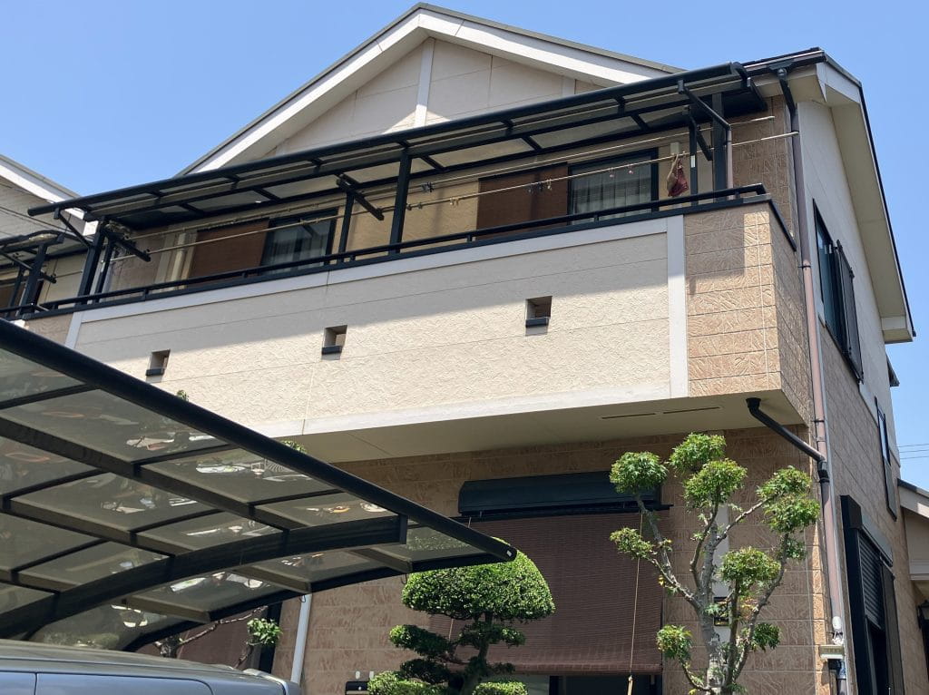 施工前の全景写真です。飯田産業住宅で、外壁はサイディングです。サイディングですのでシーリング撤去打ち替えもあります。また、雨樋や水切りといった付帯部の塗装も行います。