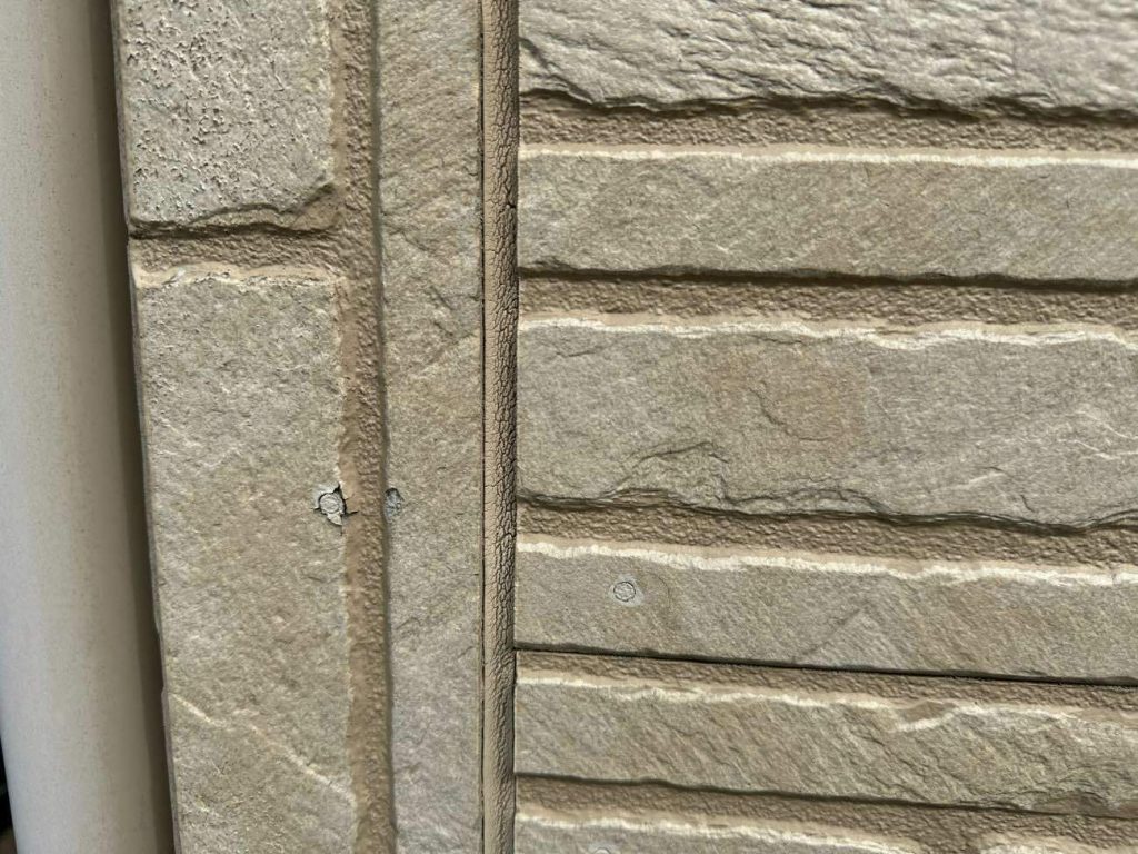 施工前の窯業系サイディングの写真です。日の当たらない面にコケの発生と釘まわりからのひび割れが発生している部分がありました。