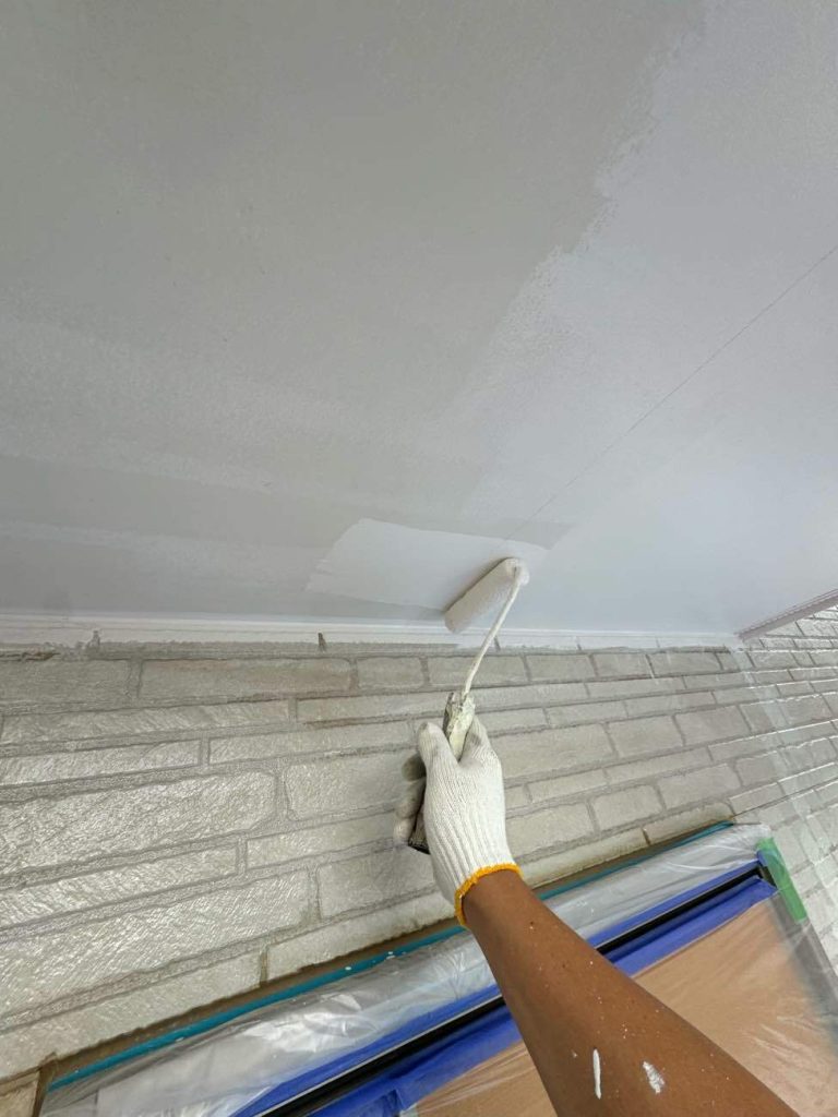 軒天（屋根の裏側）の2回目の塗装を行っている様子です。軒天は湿気が溜まりやすい場所のため、透湿性のある防カビ塗料を使用しています。明るいお色（N-90）をローラーで丁寧に2回塗り重ねることで、カビを防ぎ、長期間美観を保ちます。