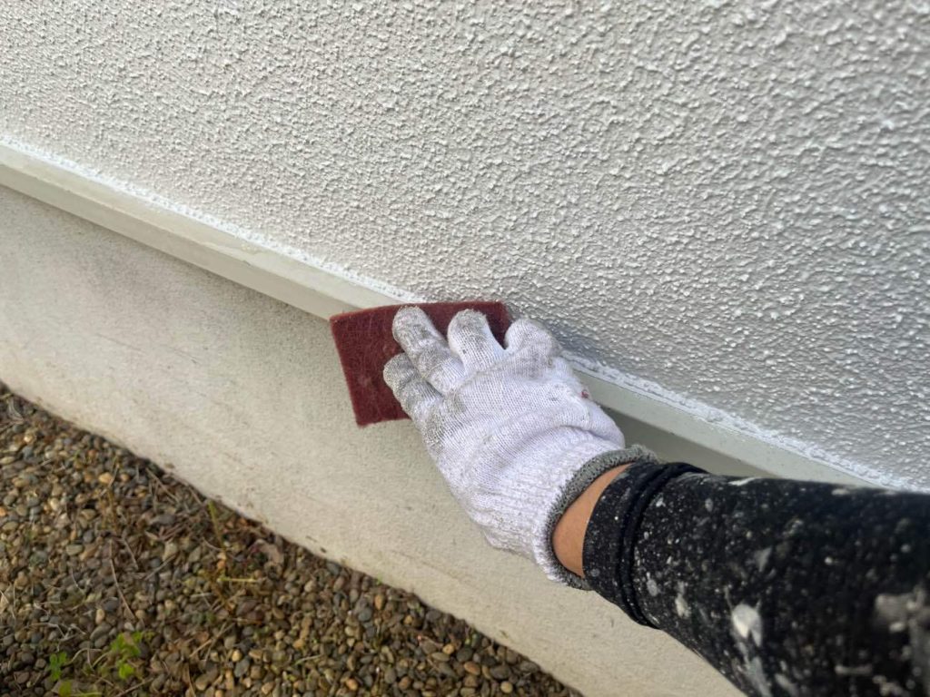 雨樋や水切り、シャッターボックスなどの付帯部の下地処理（ケレン作業）と下塗り工程です。サンドペーパーで表面を研磨して汚れやサビを落とし、塗料の密着を高める目荒らしを行います。その後、鉄部にはサビ止め塗料を塗布するなど、素材に合わせた専用の下塗り材を使用して強固な基盤を作ります。