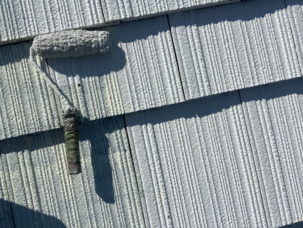 洋瓦屋根の下塗り工程です。まずは傷んだ瓦に日本ペイントファイン浸透シーラー」をたっぷりと吸わせて素地を強化した後、2回目の下塗りとして日本塗装名人社UVルーフプライマーSiを塗布します。劣化状況に合わせた2回の下塗りと、瓦ジョイント部の事前のコーキング補修により、上塗り塗料がしっかりと定着する強固な基盤を作ります。