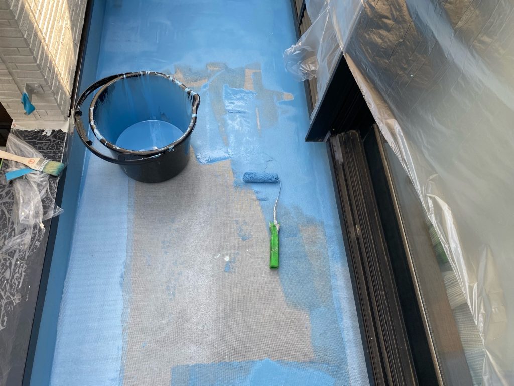ベランダのウレタン防水工事です。床面を清掃して専用プライマーを塗布後、ひび割れを防ぐ補強メッシュを敷き詰めます。その上から液状のウレタン樹脂を2層に分けて均一に塗布し、継ぎ目のない強靭な防水層を形成します。最後に紫外線から防水層を守るグレーのトップコートを塗り重ねて仕上げます。
