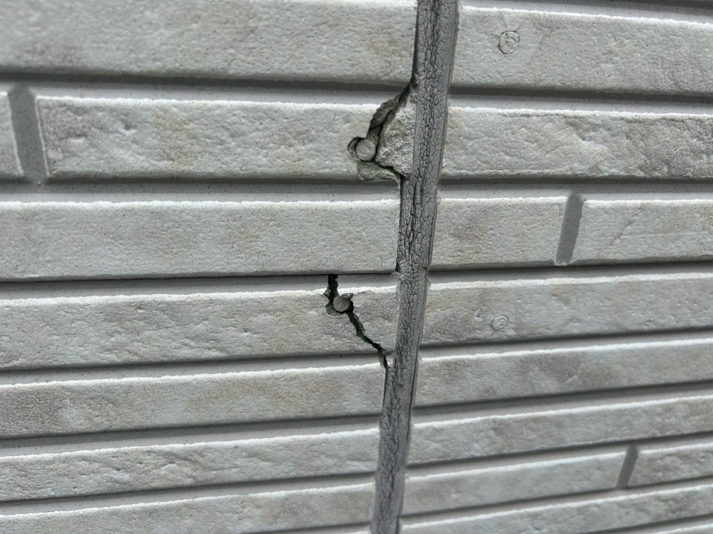 施工前のサイディングの状態です。釘を打っている箇所を中心に、ひび割れ（クラック）や一部欠損が見受けられました。これは、経年によりサイディング材自体の防水性が低下し、雨水の吸水と乾燥による伸縮を繰り返すことで、固定している釘まわりに負荷がかかり発生する現象です。放置するとここから雨水が浸入し、下地の腐食やボードの反りを引き起こす原因となります。塗装工程に入る前に、こうした傷みの一つひとつをコーキングや専用のパテで丁寧に補修し、下地を万全な状態に整えてから塗り替えを行います。