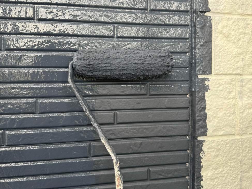 下塗りで整えた土台の上に、メインの仕上げ塗料「日本塗装名人社 無機UVコート水性」を塗布する工程です。塗装は「中塗り」と「上塗り」の2回に分けて丁寧に行います。まず中塗りで塗膜の適正な厚みを確保して耐久性の基盤を作り、乾燥後に上塗りを重ねて色ムラのない美しい艶と強靭な塗膜を完成させます。この塗料は紫外線に強い無機成分を配合した、約15年の耐久性を誇る超高耐候ハイブリッド塗料です。長期間にわたって色あせや汚れの付着を防ぎ、お住まいの美観を長く保ち続けます。