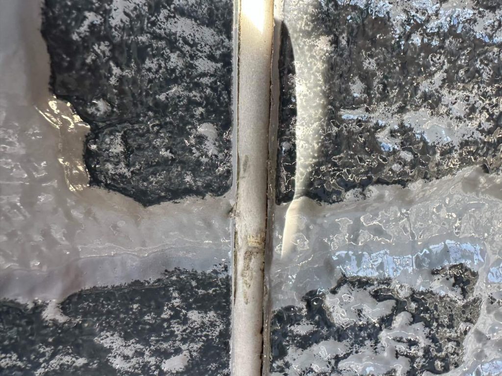 外壁の目地を埋めている古いシーリング材の撤去工程です。ユウマペイントでは、古い材の上から新しいものを被せるだけの簡易的な「増し打ち」ではなく、古いものを根元からすべて剥がす「撤去・打ち替え」を標準仕様としています。経年劣化で硬化し、ひび割れや隙間が生じたシーリング材をカッターで丁寧に取り除き、サイディングの断面を完全に露出させます。この徹底した撤去作業が、新しいシーリング材の密着性を高める重要な工程になります。