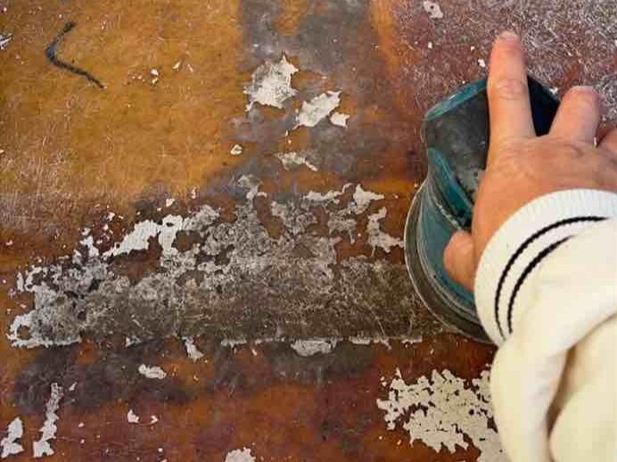 既存のFRP防水面を電動サンダーなどで丁寧に削る「ケレン（目粗し）」の工程です。長年の雨風や紫外線によって硬くなった表面の古い塗膜を削り取り、あえて微細な傷をつけて表面を荒らすことで、新しく重ねる防水材が剥がれにくくなるための足場を作ります。この工程を丁寧に行うことで、新しい防水層が下地としっかりと一体化し、将来的な「浮き」や「剥離」を未然に防ぐことができます。ベランダの防水機能を長持ちさせるために欠かせない、非常に重要な下地処理です。