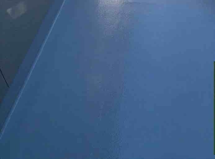 防水工事の最終仕上げとなる「トップコート」の塗布工程です。FRPの防水層自体は紫外線に弱いため、この高耐久なトップコートで表面をしっかりとコーティングし、太陽光や雨風、摩擦などの外部ダメージから防水層を保護します。専用のローラーを用いてムラなく塗り上げることで、優れた耐候性を付与するとともに、美しい艶のあるベランダへと生まれ変わります。お住まい全体の塗装メンテナンスと同様に、ベランダの防水機能もこの最終工程によって最良の状態で維持されることになります。