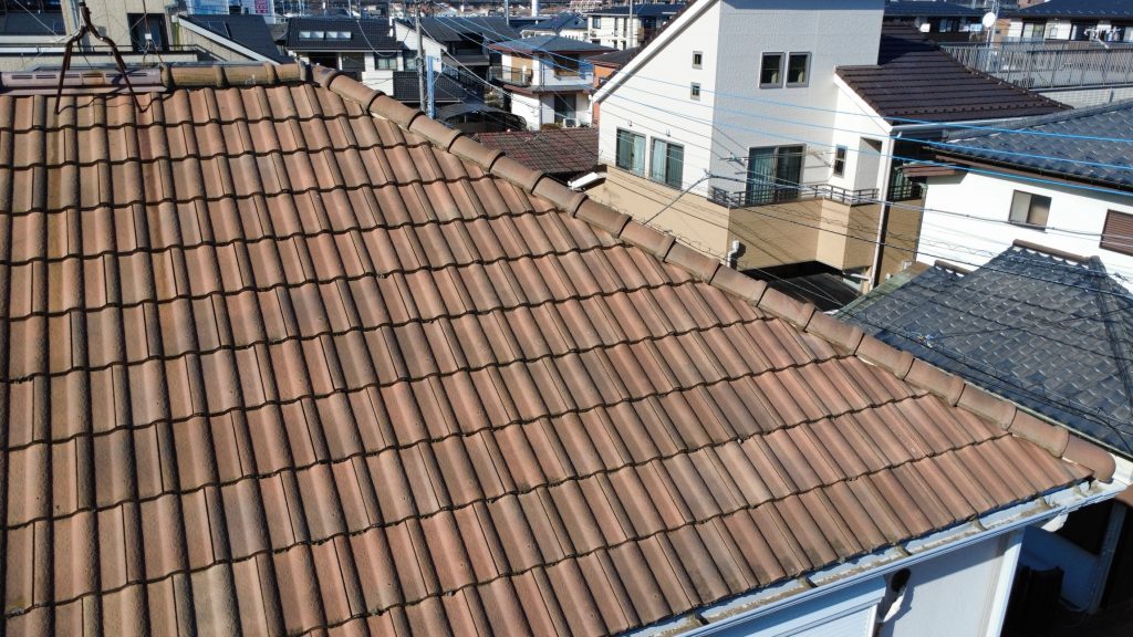 施工前の洋瓦屋根の様子です。洋瓦は非常に耐久性が高く、塗装によるメンテナンスは不要な屋根材です。しかし経年により表面には苔や土埃などの汚れが蓄積して美観を損ねていました。今回の工事では高圧洗浄で長年の汚れをきれいに洗い流し、瓦本来の美しさを取り戻します。また、冬場の積雪に備えて新たに雪止めを設置し、雨樋の破損や落雪による隣家へのトラブルを未然に防ぐ対策を足場があるこの機会に行います。
