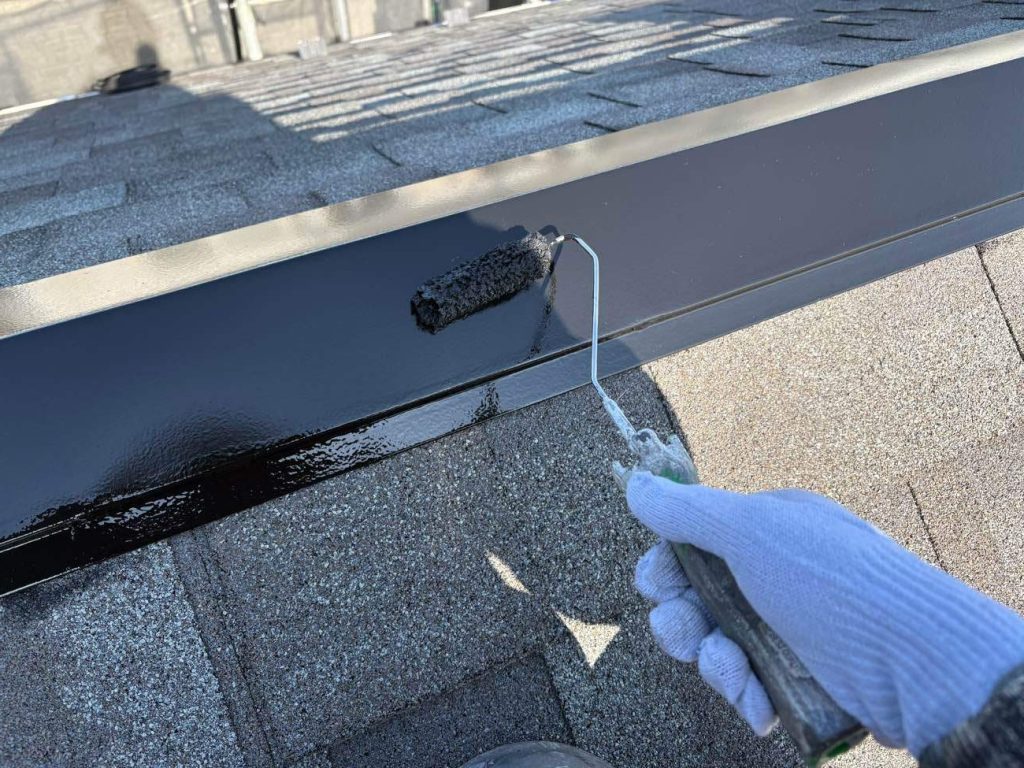 アスファルトシングル屋根の金属部（棟板金やケラバ、谷、雨押えなど）のメンテナンス工程です。浮いている釘を打ち直してコーキングで抜け防止処理を行い、ケレン作業後にサビ止め塗料を下塗りします。その後、黒色のフッ素UVコート溶剤を2回塗り重ねて強靭な保護膜を形成し、雨風の影響を受けやすい屋根の金属部を強固に守ります。