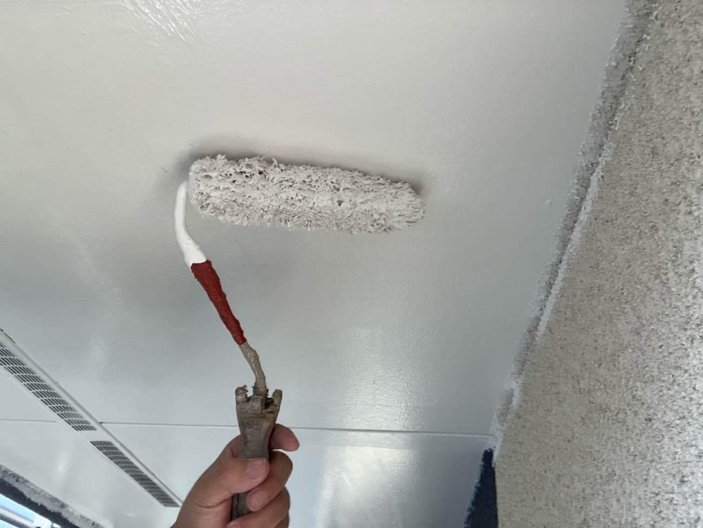 下塗りが乾燥した後、仕上げ用の塗料を2回塗り重ねていく工程です。軒天井には、建物内部からの湿気を外へ逃がす特性を持つ「透湿性防カビ塗料」を使用します。まず中塗りで均一に膜厚を確保し、乾燥時間を守った後に上塗りを重ねることで、塗料が持つ防カビ性能や耐久性を最大限に引き出します。艶を抑えたマットな質感に仕上げることで、軒先を清潔感のある明るい印象に整えます。