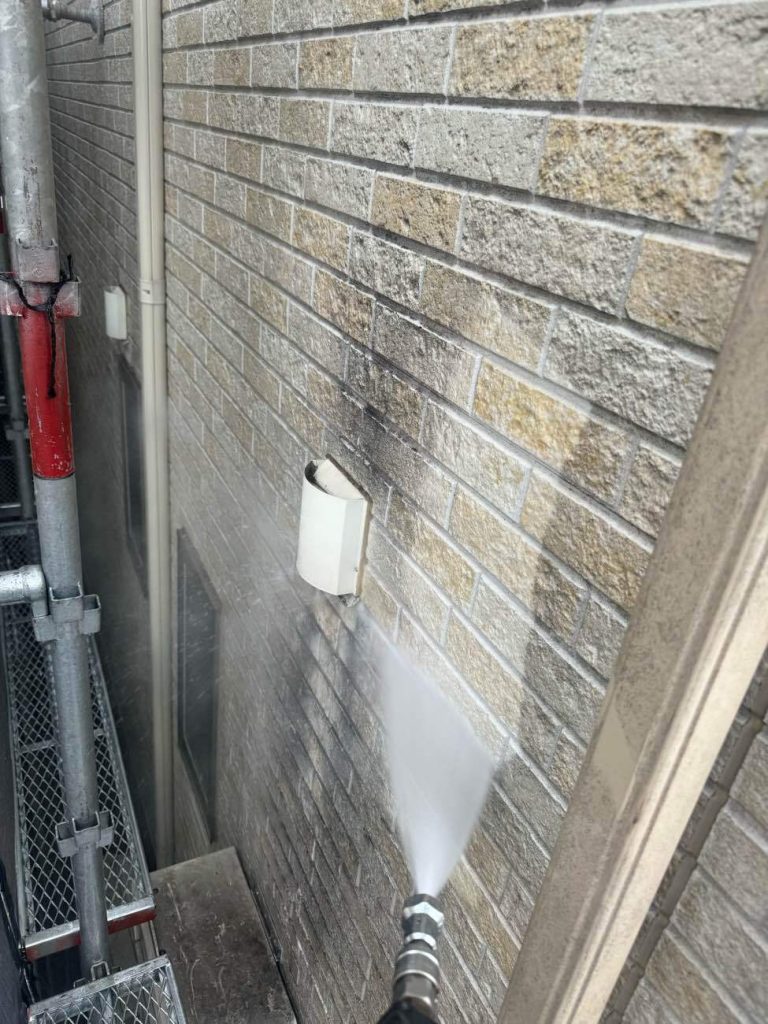 ビケ足場と飛散防止ネット（屋根落下防止手摺り含む）を設置し、12Mpa~15Mpaの高圧洗浄で外壁と屋根の汚れを落とします。東面には専用の除去剤を使用し、汚れを根こそぎ落としました。