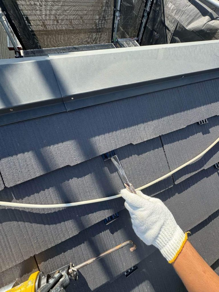 スレート屋根に「ファイン浸透シーラー」を塗布して補強し、雨水の抜け道を確保する縁切り部材「タスペーサー」を挿入します。