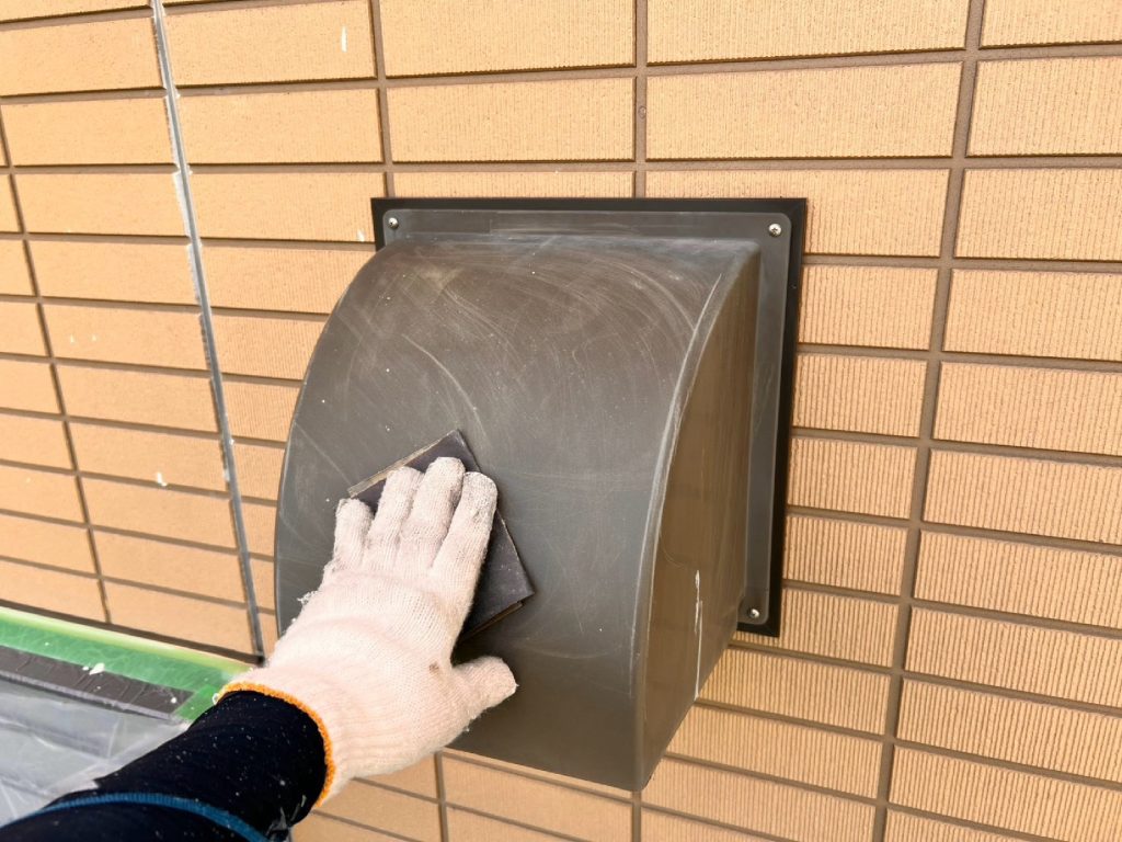 屋外に露出する換気フードは、経年で汚れや錆が付着しやすい部位です。ケレンとシンナー拭きを丁寧に行い、塗料がしっかりと密着する下地を作る工程です。