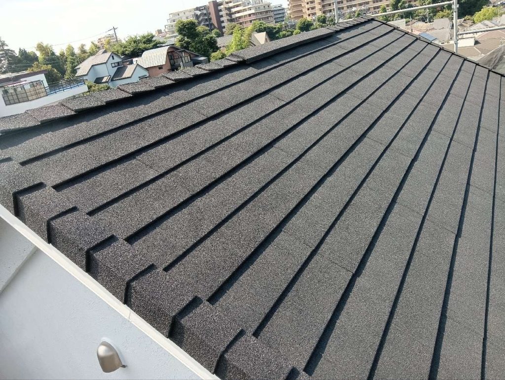 施工後の屋根です。既存のコロニアルの上に、軽量で高耐久な金属屋根「ディプロマット（オニキス）」を重ね葺きするカバー工法が完了しました。落ち着いた色合いで、屋根全体の印象がすっきりと引き締まっています。