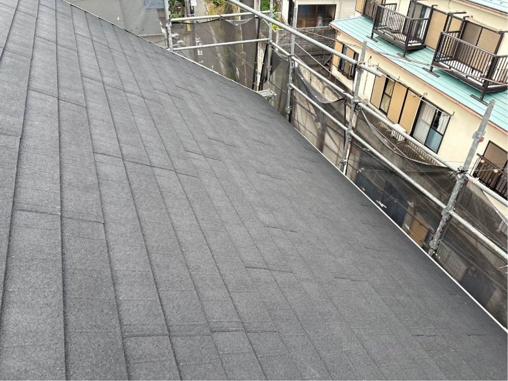 防水シートの上から、新しい金属屋根材であるディーズルーフ「ディプロマット（オニキス）」を葺いていきます。非常に軽量で建物への負担が少なく、耐久性にも優れた屋根材です。下から上に向かって一枚ずつ固定していきます。