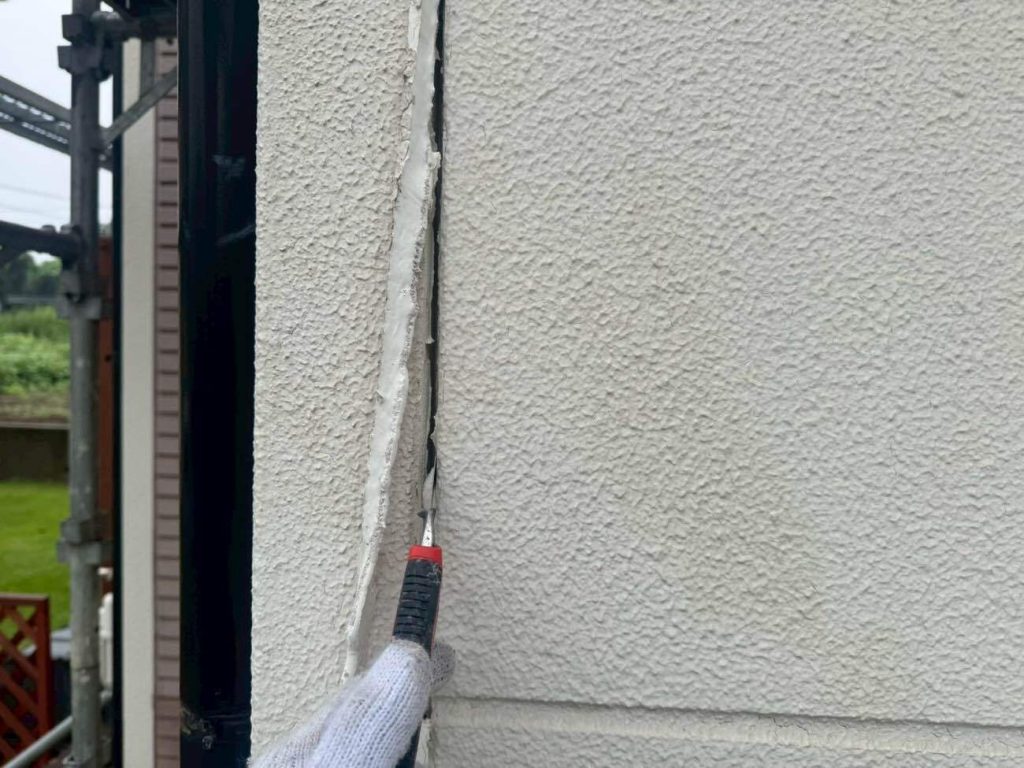 ALCパネルの目地に打たれた既存シーリングを、カッターですべて撤去します。劣化した古い材料を残さず取り除き、新しいシーリングが密着する状態に整える工程です。